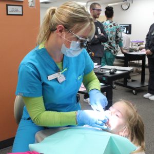 CVTC dental hygienist student Kelsey Wirth cleans the teeth of Anya Adkins, 4, of Eau Claire.