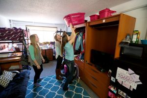 From left, triplets Joni, Jeni and Jami Donath clean their CKTO residence hall room at UW-Stout.