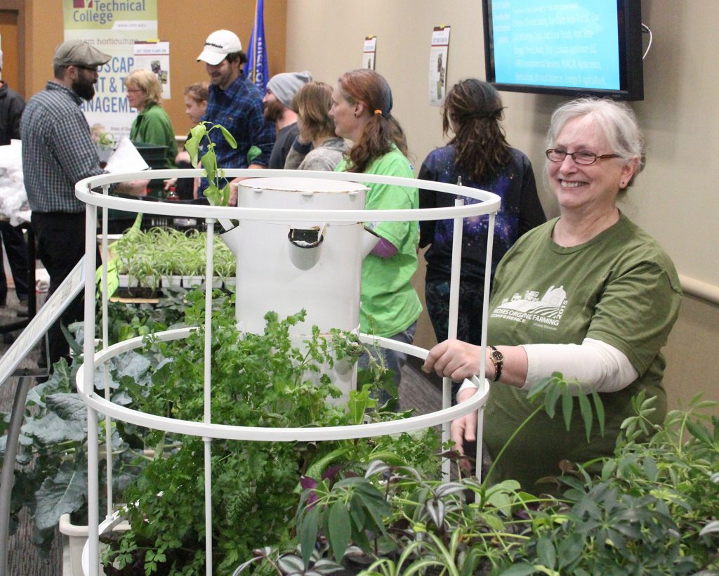 CVTC student Mary Gehrke displays a hydroponic herb and produce garden at an Earth Day event on campus.