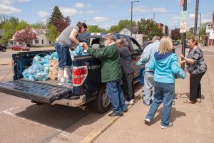 Food collected during the "Stamp Out Hunger" food drive is unloaded by volunteers at the Salvation Army Food Pantry in Chippewa Falls. 