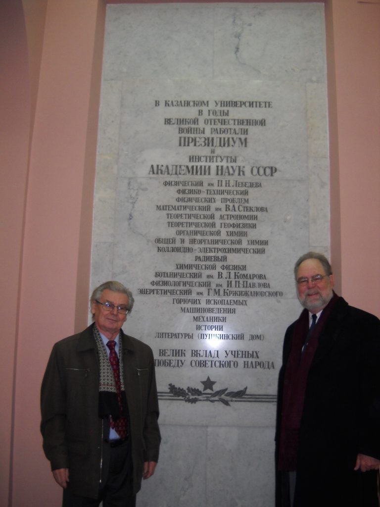Kazan academician Alexander Konovalov and David Lewis in front of a wall plaque in the main university building at Kazan Federal University. 